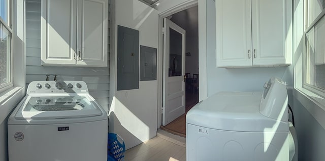 clothes washing area with cabinet space, washing machine and dryer, and electric panel