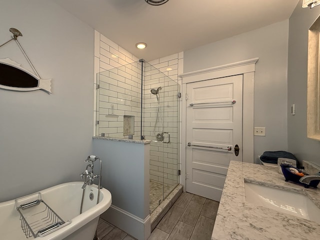 bathroom featuring wood finish floors, a freestanding tub, a sink, and a shower stall