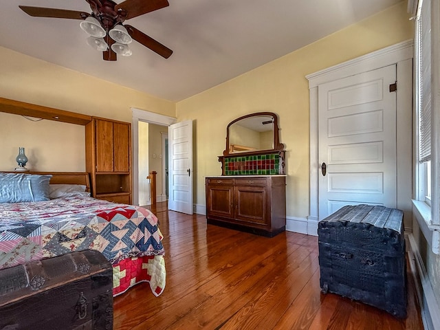 bedroom featuring ceiling fan, baseboards, and wood finished floors