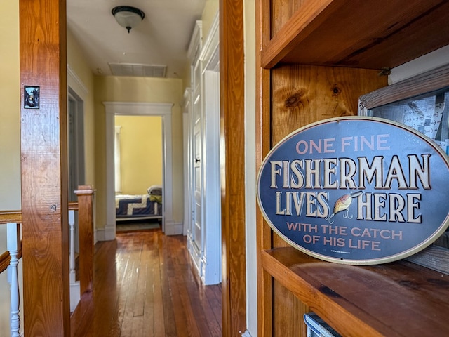 hallway with hardwood / wood-style floors and visible vents