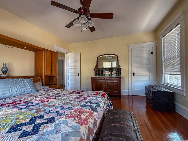 bedroom with dark wood-style flooring, ceiling fan, and baseboards