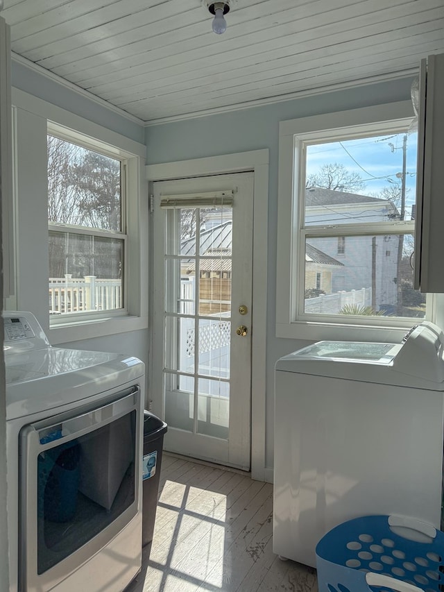 laundry room with laundry area, crown molding, light wood-style flooring, and washing machine and clothes dryer