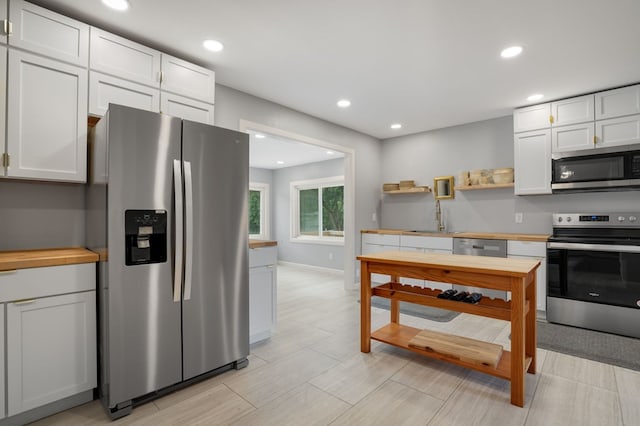 kitchen with appliances with stainless steel finishes, white cabinetry, and sink