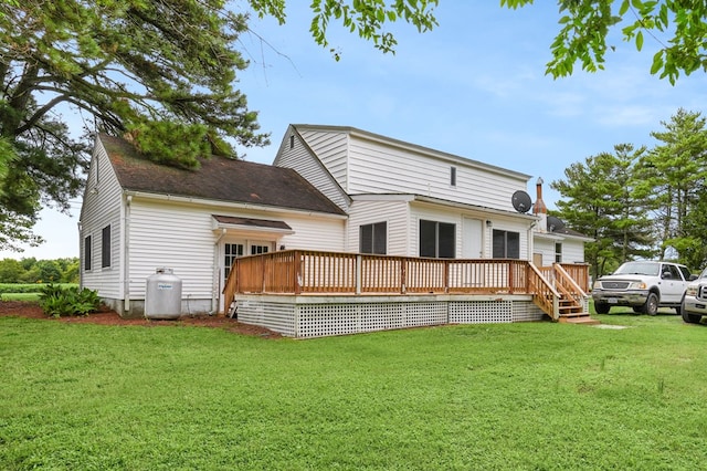 rear view of property with a yard and a deck