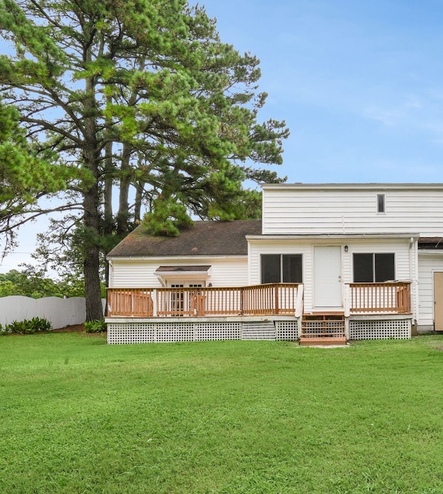 rear view of house featuring a lawn and a deck