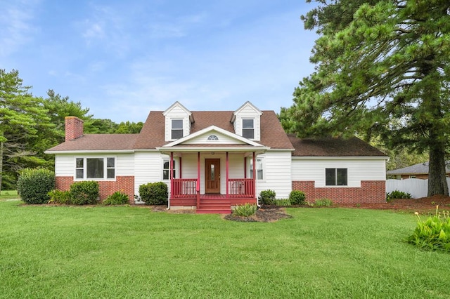 new england style home featuring covered porch and a front lawn