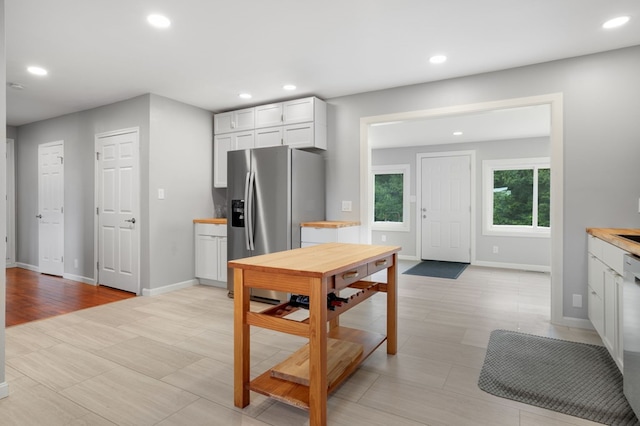 kitchen with stainless steel fridge with ice dispenser, white cabinets, and white dishwasher