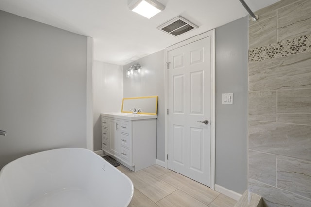 bathroom featuring vanity and a tub to relax in