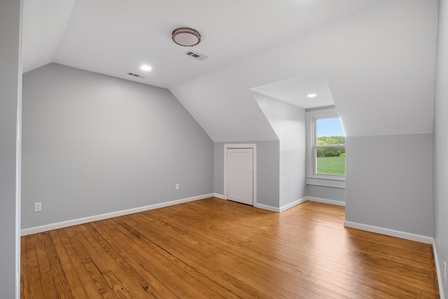 additional living space with light hardwood / wood-style floors and vaulted ceiling