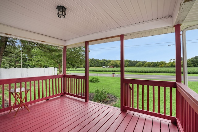 wooden terrace featuring a lawn