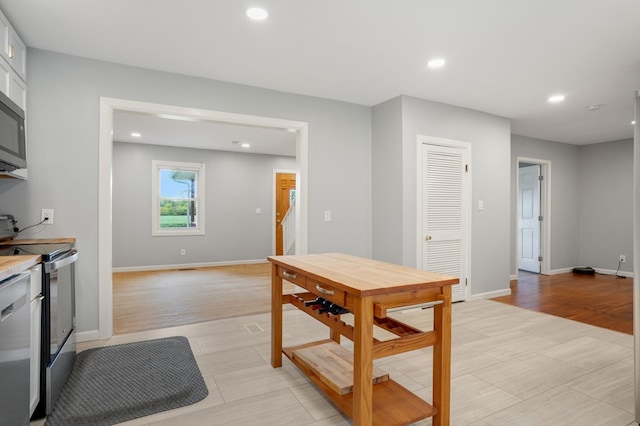 kitchen with white cabinetry, light tile patterned floors, and appliances with stainless steel finishes