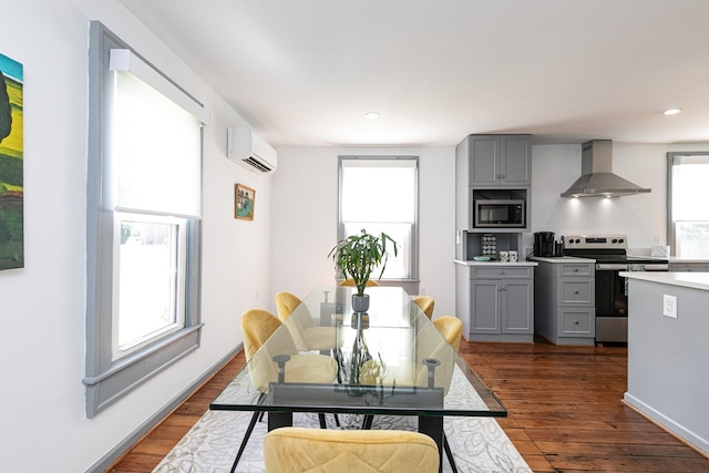 kitchen with built in microwave, gray cabinets, wall chimney range hood, and stainless steel range with electric cooktop