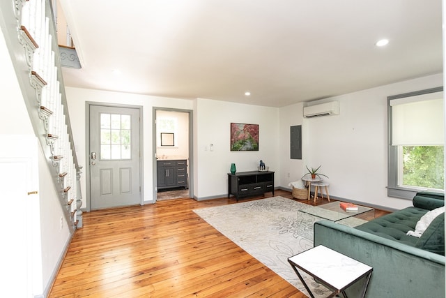 living room featuring a wall unit AC and light hardwood / wood-style floors