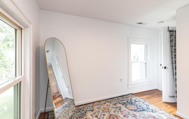 spare room featuring a wealth of natural light and light hardwood / wood-style floors