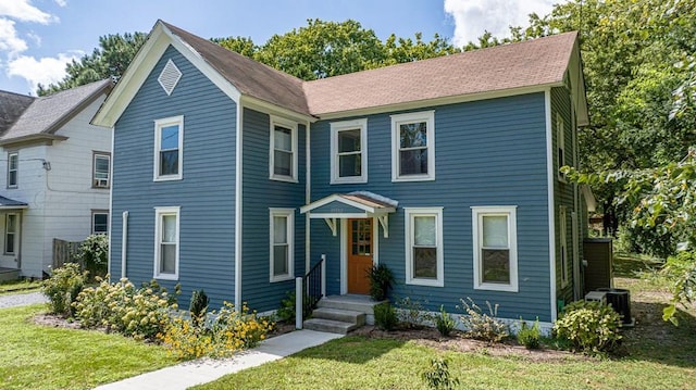 view of front facade featuring central AC and a front yard