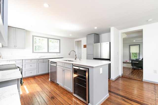 kitchen featuring sink, gray cabinets, beverage cooler, and appliances with stainless steel finishes