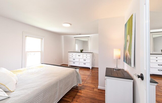 bedroom with dark hardwood / wood-style floors