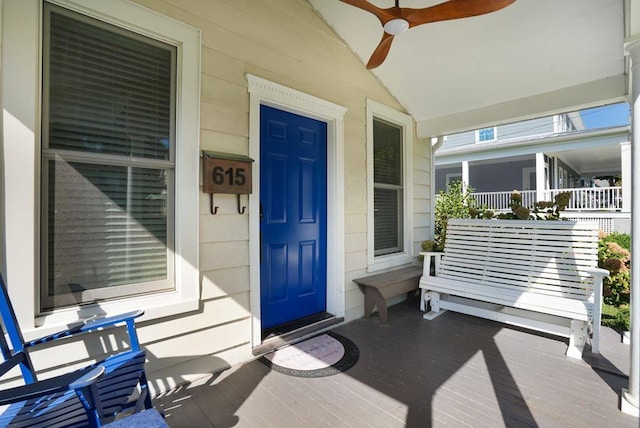 view of exterior entry featuring a porch and ceiling fan