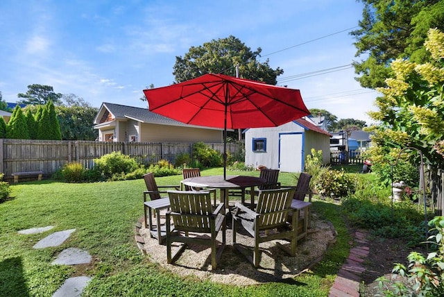 view of yard with an outdoor structure, a fenced backyard, and a shed