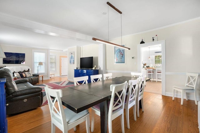 dining area with light wood-style flooring and ornamental molding