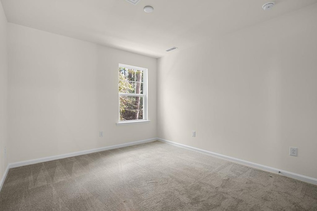 carpeted empty room with visible vents and baseboards