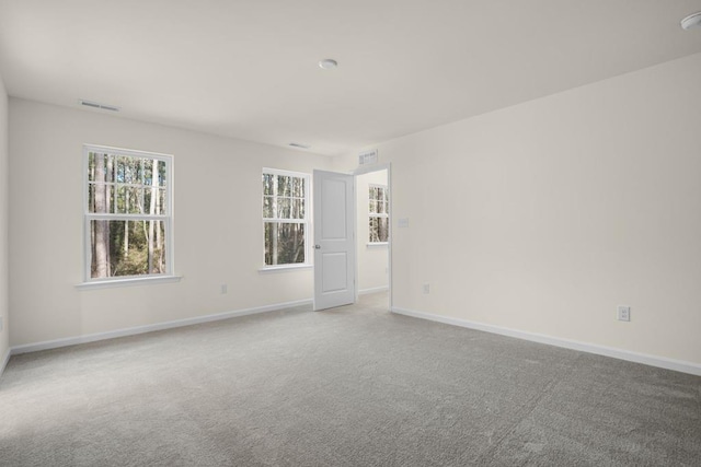 unfurnished room with baseboards, visible vents, and carpet flooring