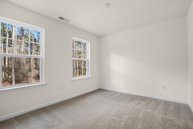 carpeted empty room with baseboards and visible vents