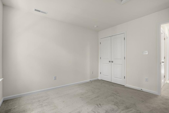 unfurnished bedroom with a closet, baseboards, visible vents, and carpet flooring