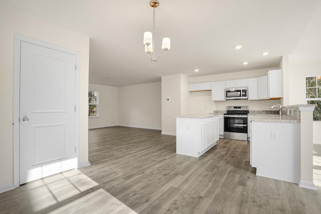 kitchen with light wood-style floors, plenty of natural light, white cabinetry, and stainless steel appliances