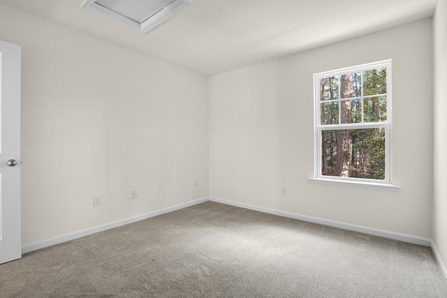 spare room featuring carpet flooring and baseboards