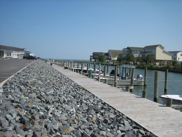 view of dock with a residential view and a water view