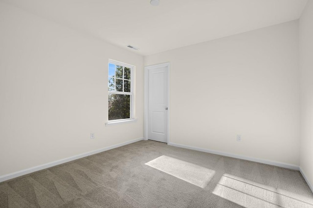 carpeted empty room with visible vents and baseboards