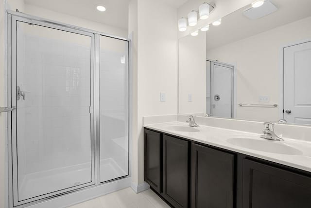 full bathroom with a stall shower, a sink, and double vanity