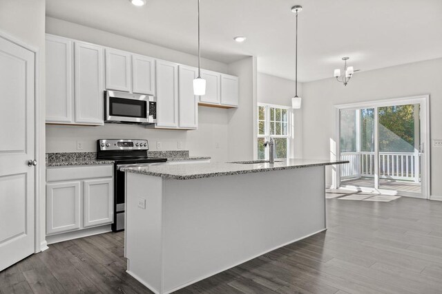 kitchen featuring light stone countertops, stainless steel appliances, a kitchen island with sink, white cabinets, and hanging light fixtures