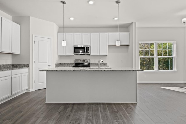 kitchen featuring white cabinets, pendant lighting, an island with sink, and stainless steel appliances