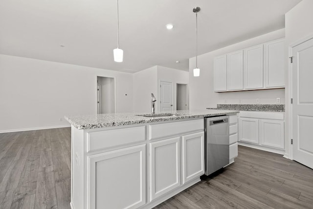 kitchen with sink, decorative light fixtures, white cabinetry, and an island with sink