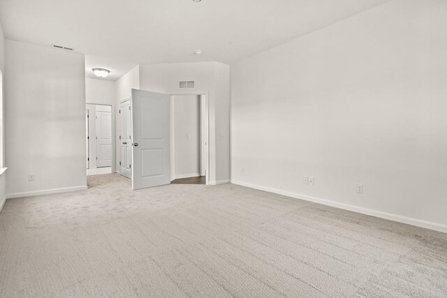 unfurnished room featuring light carpet