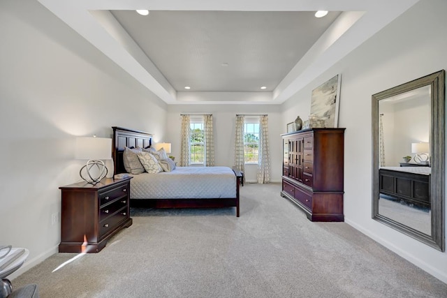 carpeted bedroom with a tray ceiling