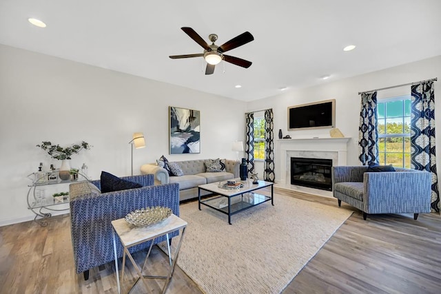 living room with a fireplace, hardwood / wood-style floors, and ceiling fan