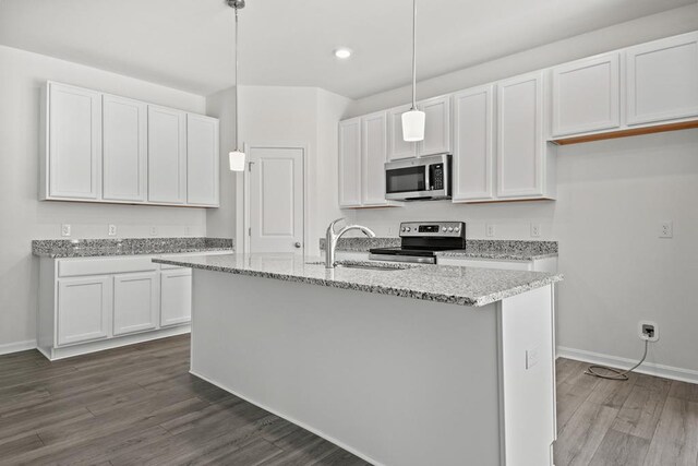 kitchen featuring dark hardwood / wood-style flooring, stainless steel appliances, white cabinets, hanging light fixtures, and an island with sink