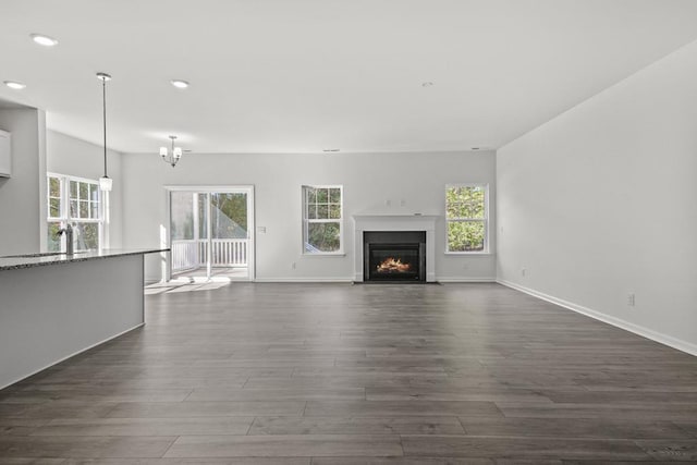 unfurnished living room featuring dark hardwood / wood-style flooring and a notable chandelier