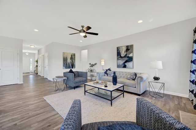 living room featuring hardwood / wood-style floors and ceiling fan