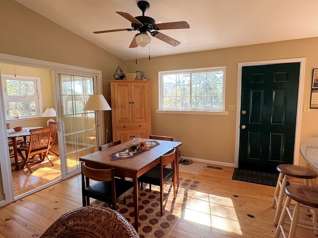 dining area with lofted ceiling, visible vents, light wood-style flooring, and baseboards