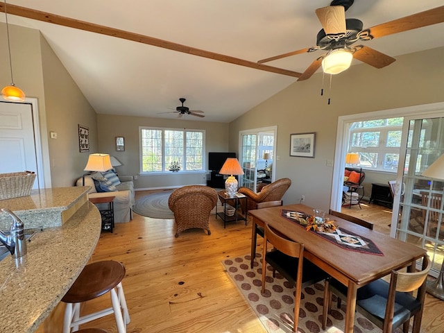 living area with a ceiling fan, light wood-type flooring, and high vaulted ceiling