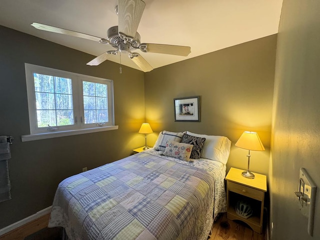 bedroom featuring ceiling fan, baseboards, and wood finished floors