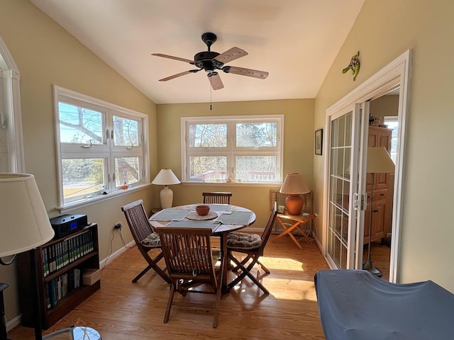 dining area with a ceiling fan, lofted ceiling, baseboards, and wood finished floors