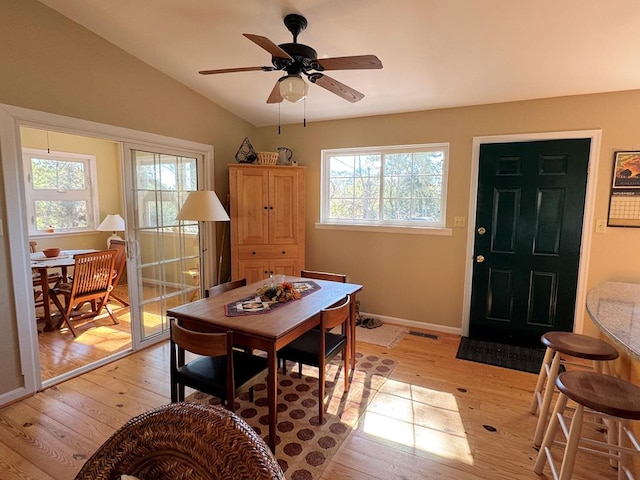 dining room with lofted ceiling, plenty of natural light, light wood-type flooring, and baseboards