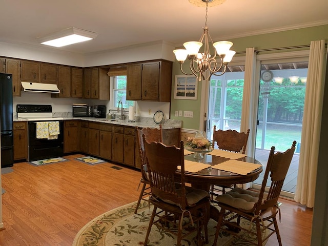 kitchen featuring sink, white electric range oven, a notable chandelier, light hardwood / wood-style floors, and decorative light fixtures