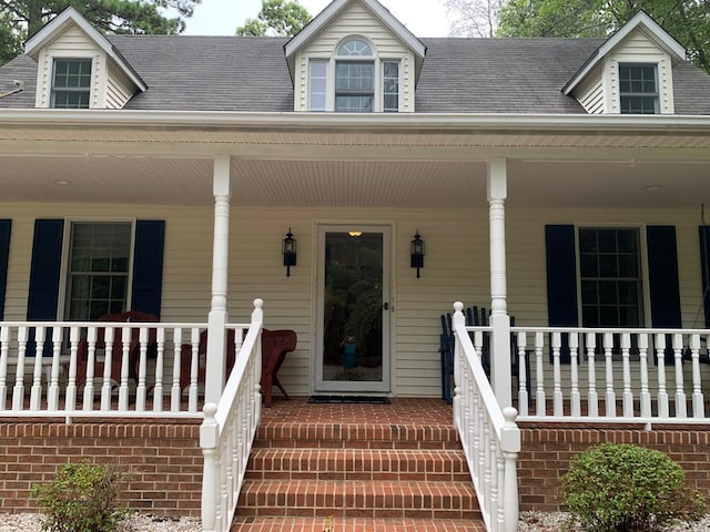 view of exterior entry featuring covered porch