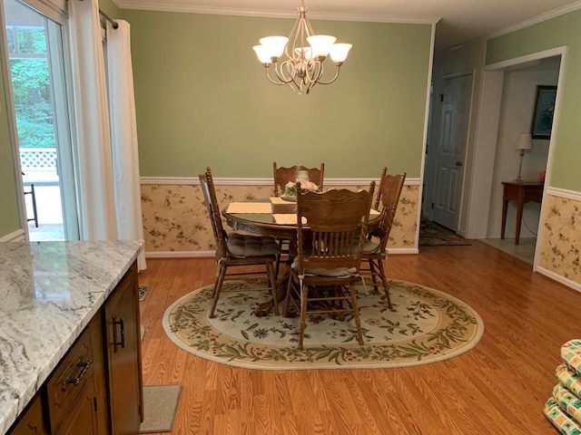 dining area with crown molding, a notable chandelier, and light wood-type flooring